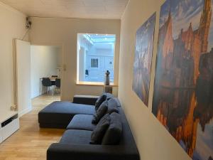 a living room with two couches and paintings on the wall at Cosy little house in Bruges