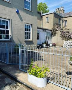 a fence in front of a house with flowers at Little Woodbank in Portadown