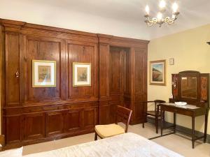 sypialnia z drewnianymi szafkami, stołem i łóżkiem w obiekcie CESARE'S HOME w Katanii