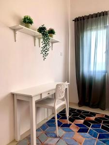 クアラ・トレンガヌにあるBunga Homestay Hill Viewの窓のある客室で、白いデスクと椅子が備わります。