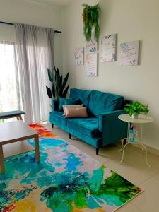 a living room with a blue couch and a colorful rug at Bunga Homestay Hill View in Kuala Terengganu