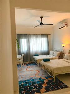 a hotel room with two beds and a table at Bunga Homestay Hill View in Kuala Terengganu