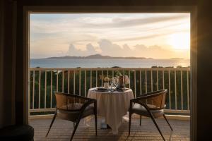 a table on a balcony with a view of the ocean at Cross Pattaya Pratamnak - SHA Plus in Pattaya South