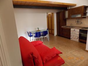 ein Wohnzimmer mit einem roten Sofa und einer Küche in der Unterkunft Il gatto con gli stivali suite - locazione turistica in Florenz