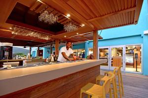 a man standing at a bar in a restaurant at Oyster Bay Beach Resort in Dawn Beach