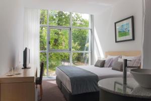 a bedroom with a bed and a large window at Boticas Hotel Art & SPA in Boticas