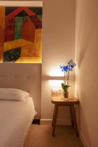 een slaapkamer met een bed en een tafel met bloemen erop bij Hotel Morgana in Mendrisio +37 foto's
