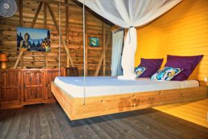 um quarto com uma cama num chalé de madeira em KAZ ANOLI "La TI KAZ" em Terre-de-Bas