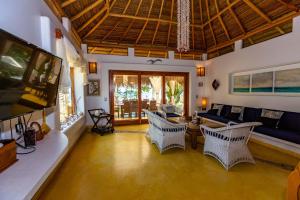 a living room with a couch and chairs in it at Casa del Rocío - Desing Beach House in Máncora