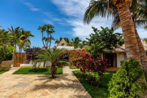 a house with a palm tree and a yard at Casa del Rocío - Desing Beach House in Máncora