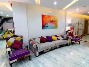 Ibrā的住宿－فندق المستقبل للشقق الفندقية ALMUSTAQBAL HOTEL Apartments，客厅配有两张沙发,墙上挂有绘画作品