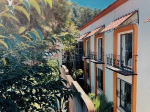 Une rangée de maisons avec balcon et arbres dans l'établissement Hotel Mansion Del Valle, à San Cristóbal de Las Casas