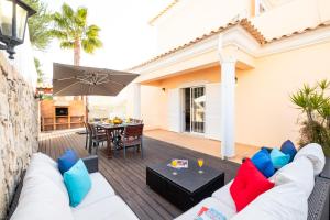 eine Terrasse mit einem weißen Sofa und einem Sonnenschirm in der Unterkunft Villa Dalia by Algarve Vacation in Almancil