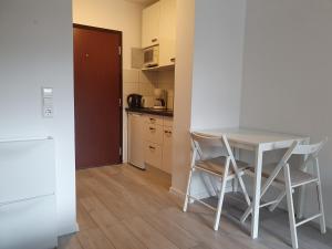 a kitchen with a table and chairs in a room at Gemütliche Ferienwohnung am Kurpark in Bad Herrenalb in Bad Herrenalb