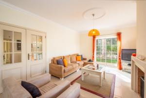 ein Wohnzimmer mit einem Sofa und einem Tisch in der Unterkunft Villa Dalia by Algarve Vacation in Almancil