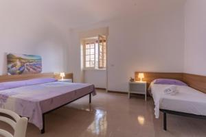 duży pokój z 2 łóżkami i oknem w obiekcie VILLA ISCHIA w mieście Torre Suda