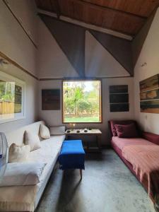 a living room with two couches and a window at Casa da Rê in Serra do Cipo
