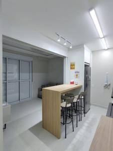 a kitchen with a counter and chairs in a room at Apartamento Pé na Areia in Florianópolis