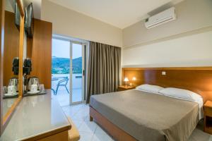 a hotel room with a bed and a balcony at Hiona Holiday Hotel in Palekastron +73 photos