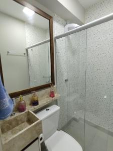 Un baño con inodoro y ducha de cristal. en Apartamento Pé na Areia, en Florianópolis