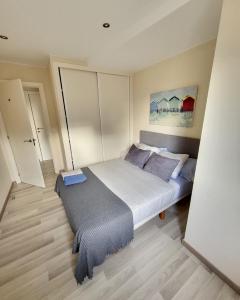 ein Schlafzimmer mit einem großen Bett mit lila Kissen in der Unterkunft Tranquilidad cerca de la playa... para vivir la ciudad in A Coruña