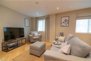 a living room with a couch and a tv at Entire 2 Bed - Free Parking - No. 15 - The Cosy Collection Ltd in York