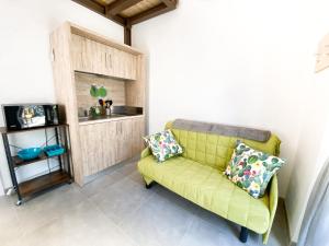 żółtą kanapę z 2 poduszkami w salonie w obiekcie New Agriloft 5 Marina Wi-Fi, Clima, Giardino, mare a 50 mt w mieście Bordighera
