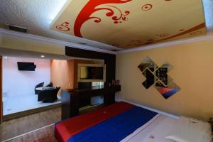 1 dormitorio con 1 cama y TV en el techo en Motel Primavera en Guadalajara