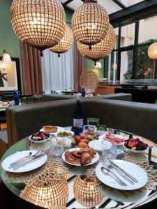 una mesa con platos de comida y lámparas de araña en The Talent Hotel, en Roma