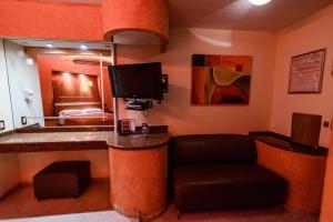 Habitación de hotel con bar con TV y cama en Motel Primavera en Guadalajara
