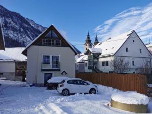 a white car parked in the snow in front of a house at Ferienhof Pacher in Spital am Pyhrn