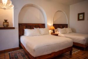 2 camas en una habitación con 2 arcos en El Alcazar, en San Miguel de Allende