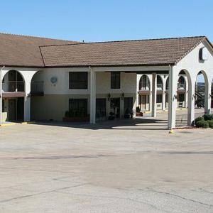 a large white building with a large parking lot at Weatherford Heritage Inn in Weatherford +10 photos