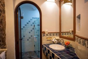 a bathroom with a sink and a glass shower at El Alcazar in San Miguel de Allende