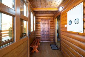 a hallway of a wooden cabin with a door and a bench at Zara Chalet in Kolašin