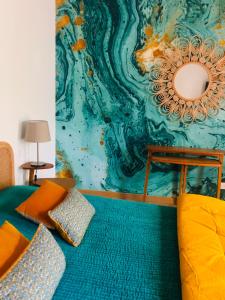een kamer met een bank en een kleurrijke muur bij Les Nuits Pétillantes in Cournonterral