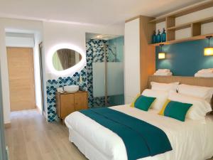 a bedroom with a large bed with a blue wall at Les Nuits Pétillantes in Cournonterral