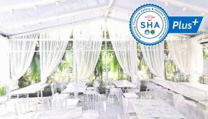 a restaurant with white chairs and a sign that reads shka plus at Hotel Chuan Chom The High Resort Saraburi in Sara Buri