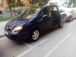 ein kleiner blauer Van auf einem Parkplatz geparkt in der Unterkunft Apartment Sarajevo Center Drvenija in Sarajevo