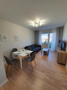 a living room with a table and chairs and a couch at Apartament APART Zagony in Wrocław