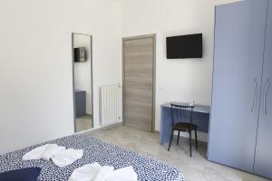 a bedroom with a bed and a desk and a television at La casa del Gabbo apartment in Monopoli