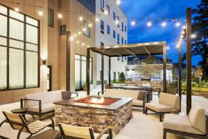 a patio with a fire pit and chairs and lights at Staybridge Suites - Auburn - University Area, an IHG Hotel in Auburn