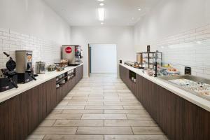 a large kitchen with a long corridor with counters at Staybridge Suites - Auburn - University Area by IHG in Auburn