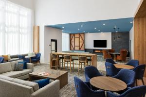 een woonkamer met banken en tafels en een televisie bij Staybridge Suites - Auburn - University Area, an IHG Hotel in Auburn