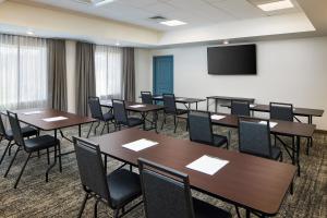 una sala de conferencias con mesas, sillas y una pantalla en Staybridge Suites - Auburn - University Area, an IHG Hotel en Auburn