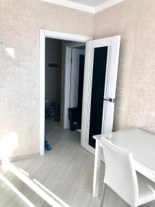 an open door to a room with a table and chairs at Уютная квартира с новым ремонтом in Leninskoye
