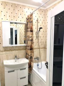 a bathroom with a sink and a shower and a tub at Уютная квартира с новым ремонтом in Leninskoye