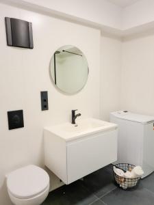 a white bathroom with a toilet and a mirror at Ferienwohnung Maja-Katharina in Bad Saarow