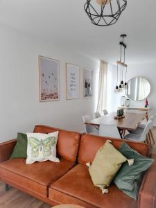 ein Wohnzimmer mit einer braunen Couch mit Kissen in der Unterkunft Ferienwohnung Maja-Katharina in Bad Saarow