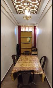 a dining room table with chairs and a ceiling at the prince apartment شقة الامير in Wadi Musa